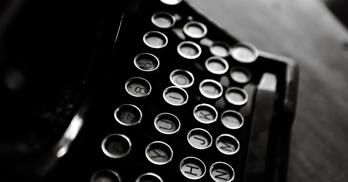 Close-up of typewriter keys in black and white, illustrating cleaning em dashes from AI text