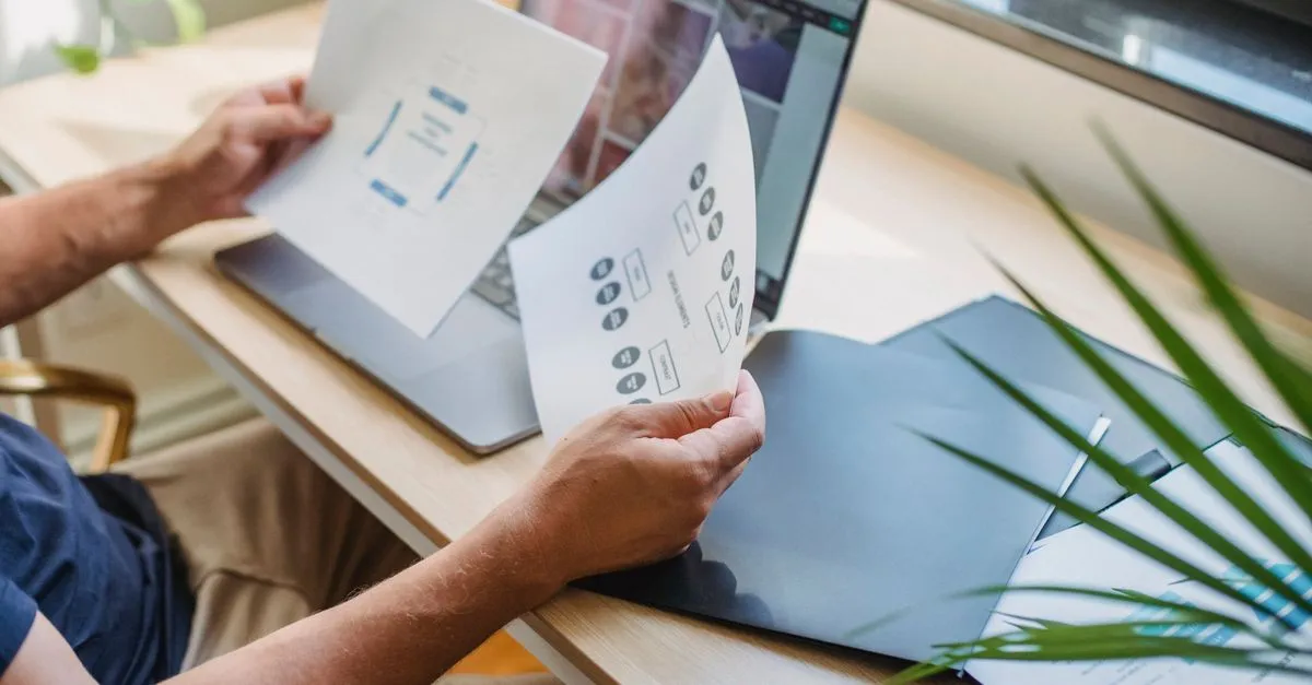 Web designer arranging rectangular layout boxes on a computer screen in a workspace