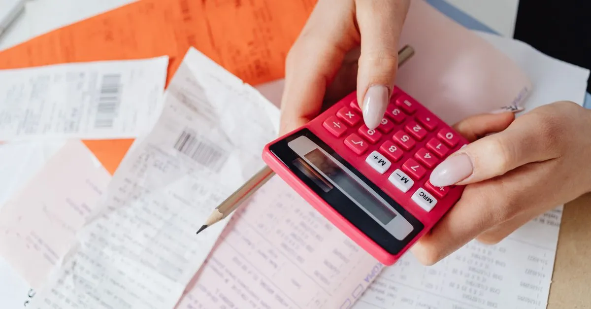 Freelancer reviewing a printed PDF invoice with line items and totals at a desk