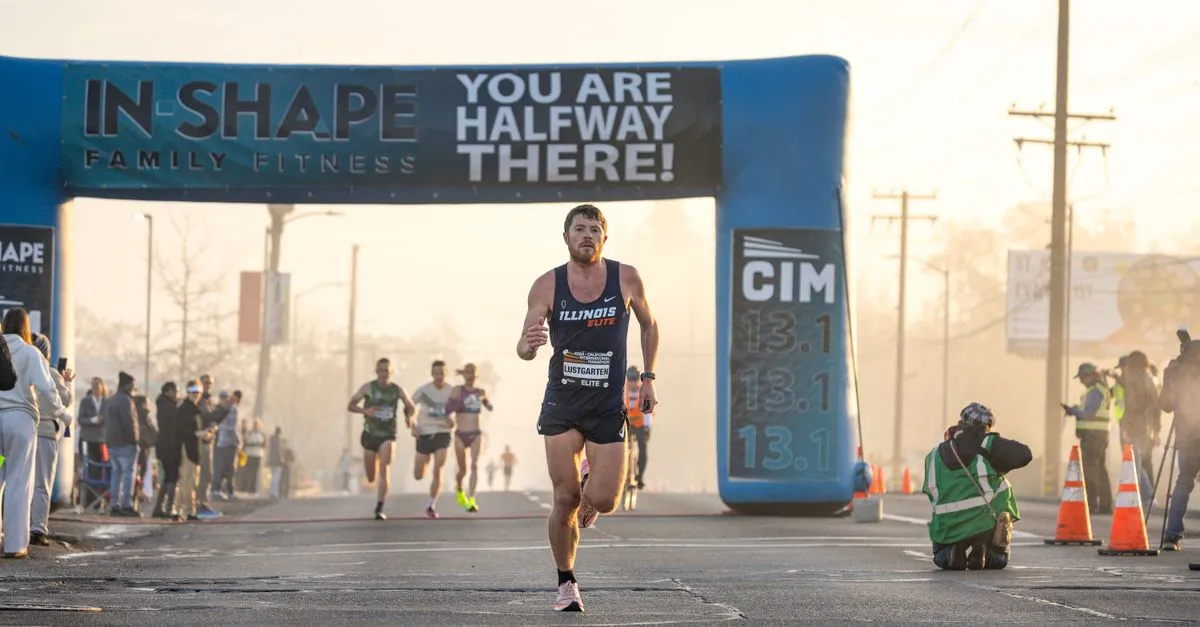 Runner on an open road holding a steady running pace during a race