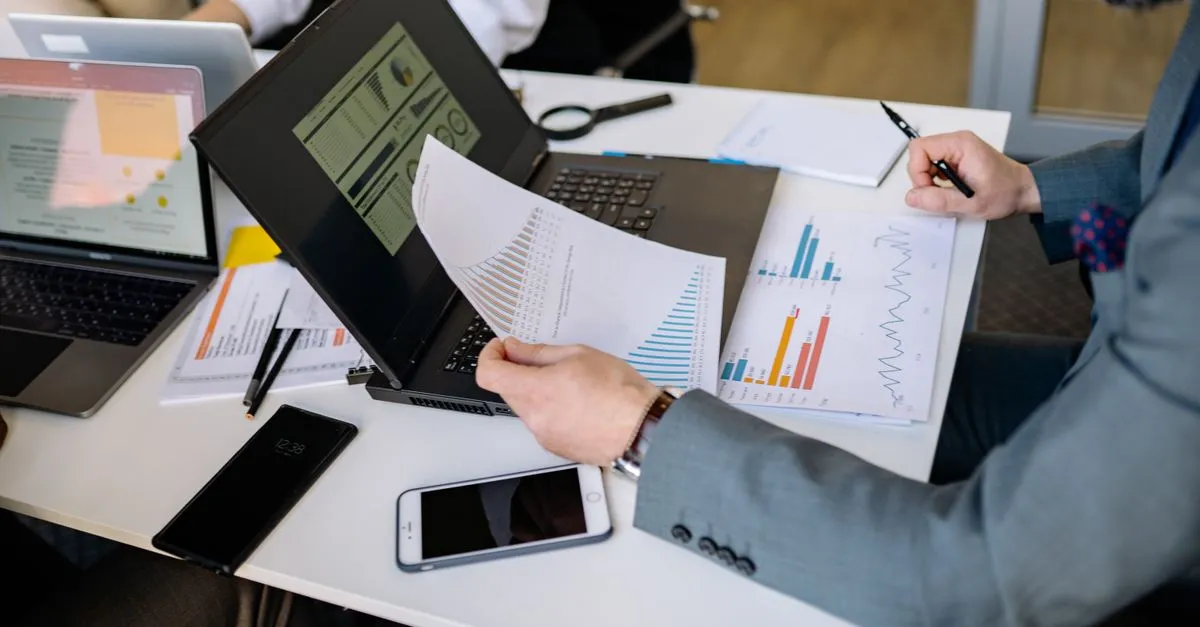 Printed documents and a laptop on a desk — converting a PDF to an editable Word document